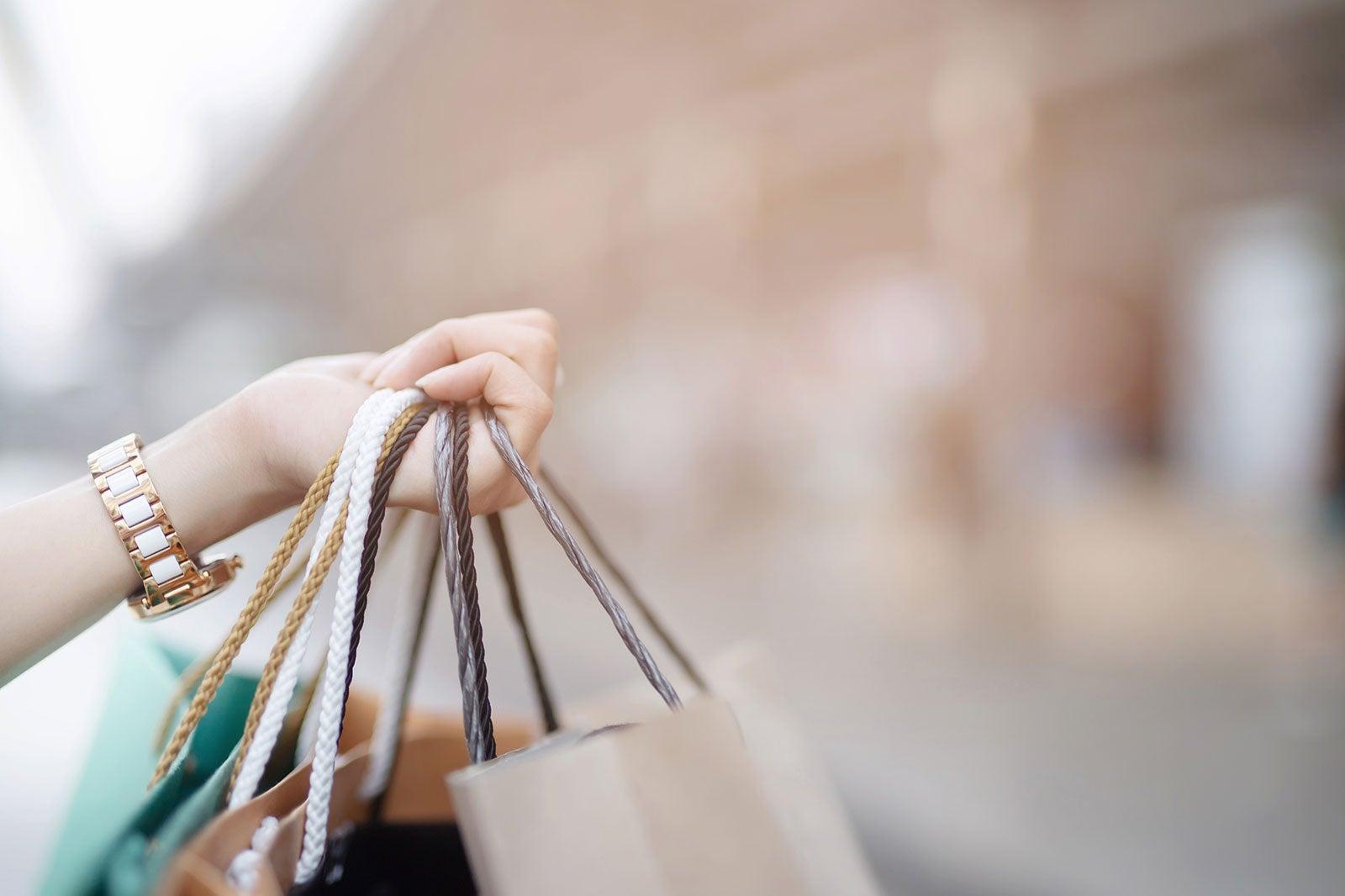 A woman's hand holding shopping bags.