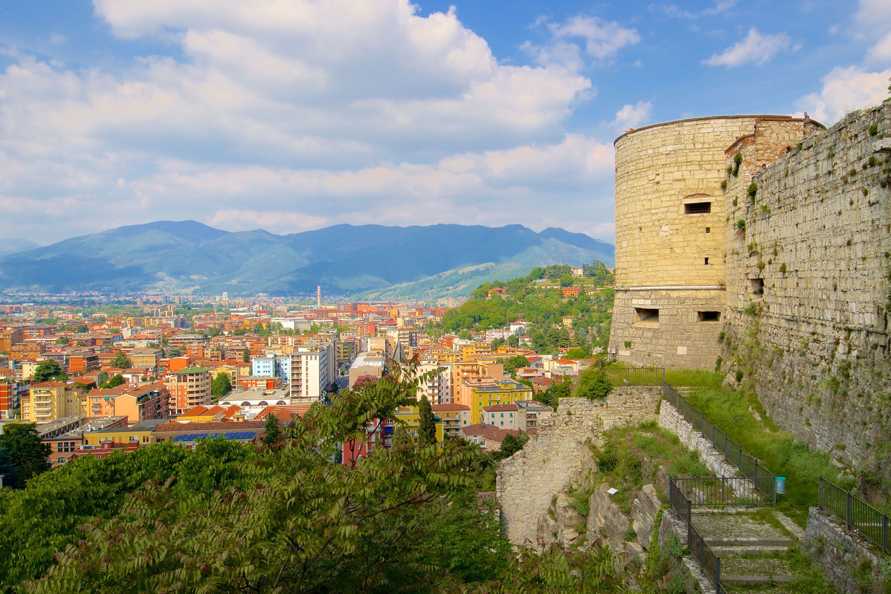 View of Brescia city from the medieval castle walls with mountains in the background.
