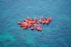 Red kayaks gathered at sea.