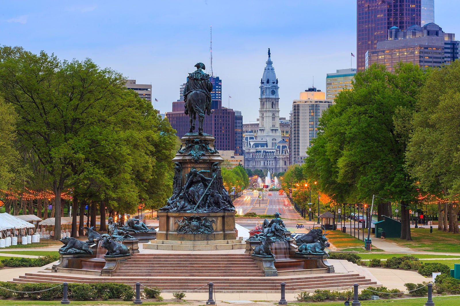 A statue and buildings with trees. 