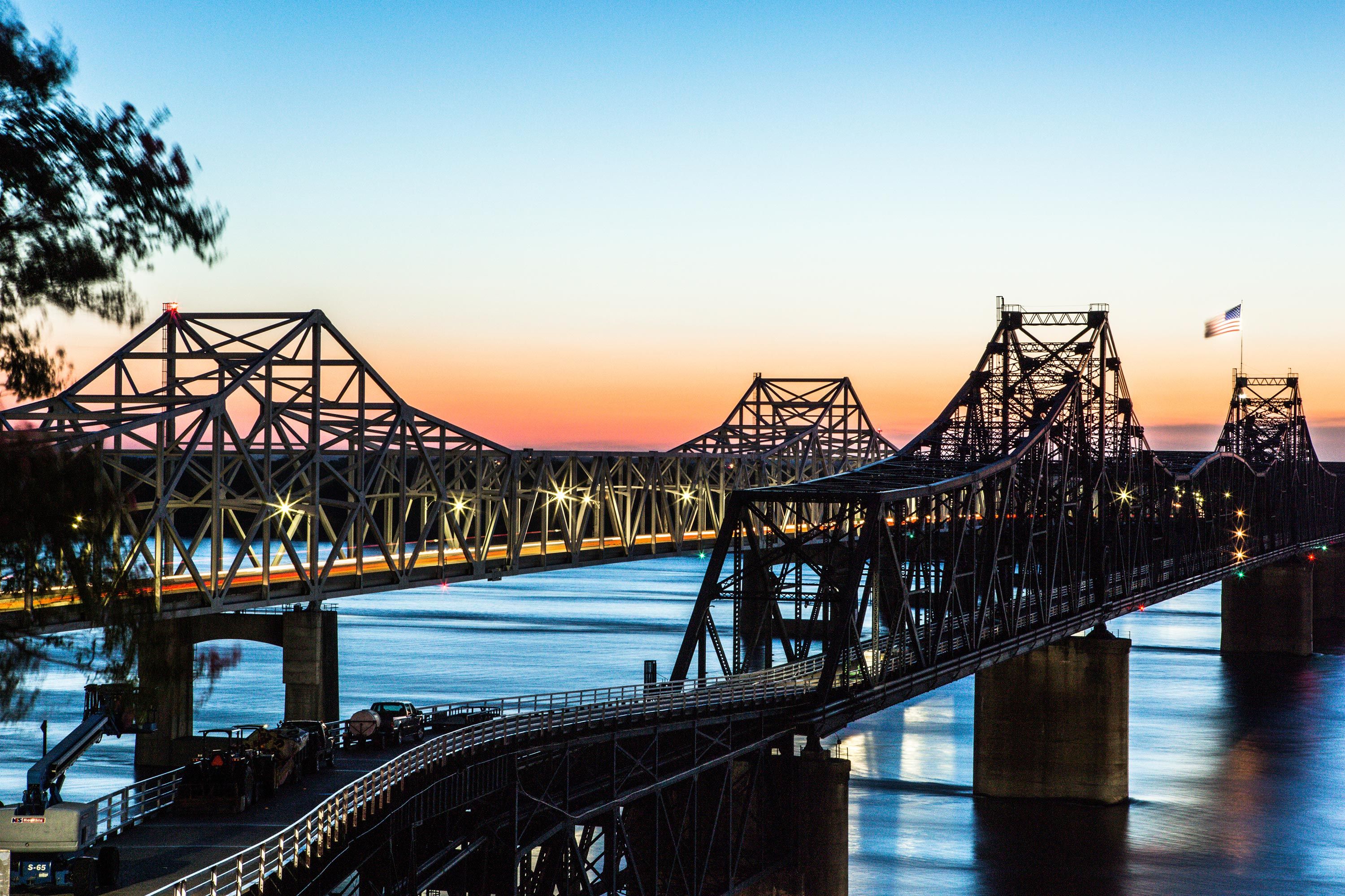 Two bridges stretch out over the Mississippi River during sunset near the Mississippi Welcome Center Overlook in Vicksburg.