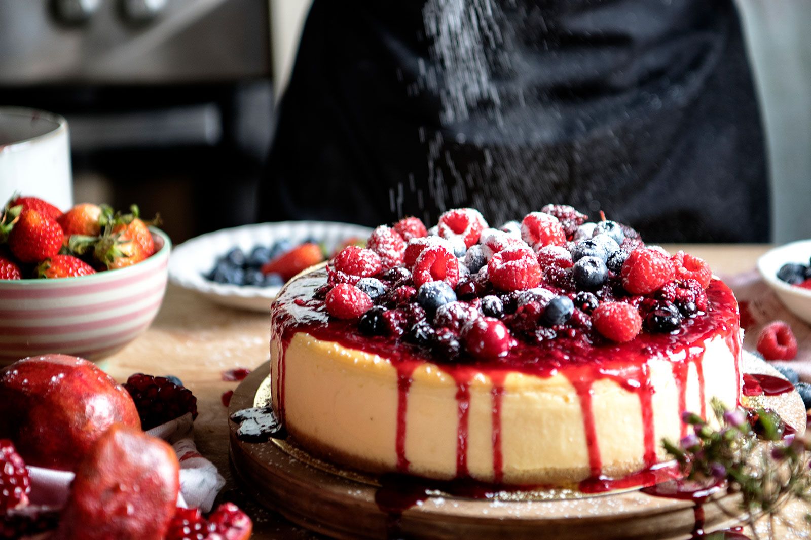 A fresh berry cheescake with powdered sugar.