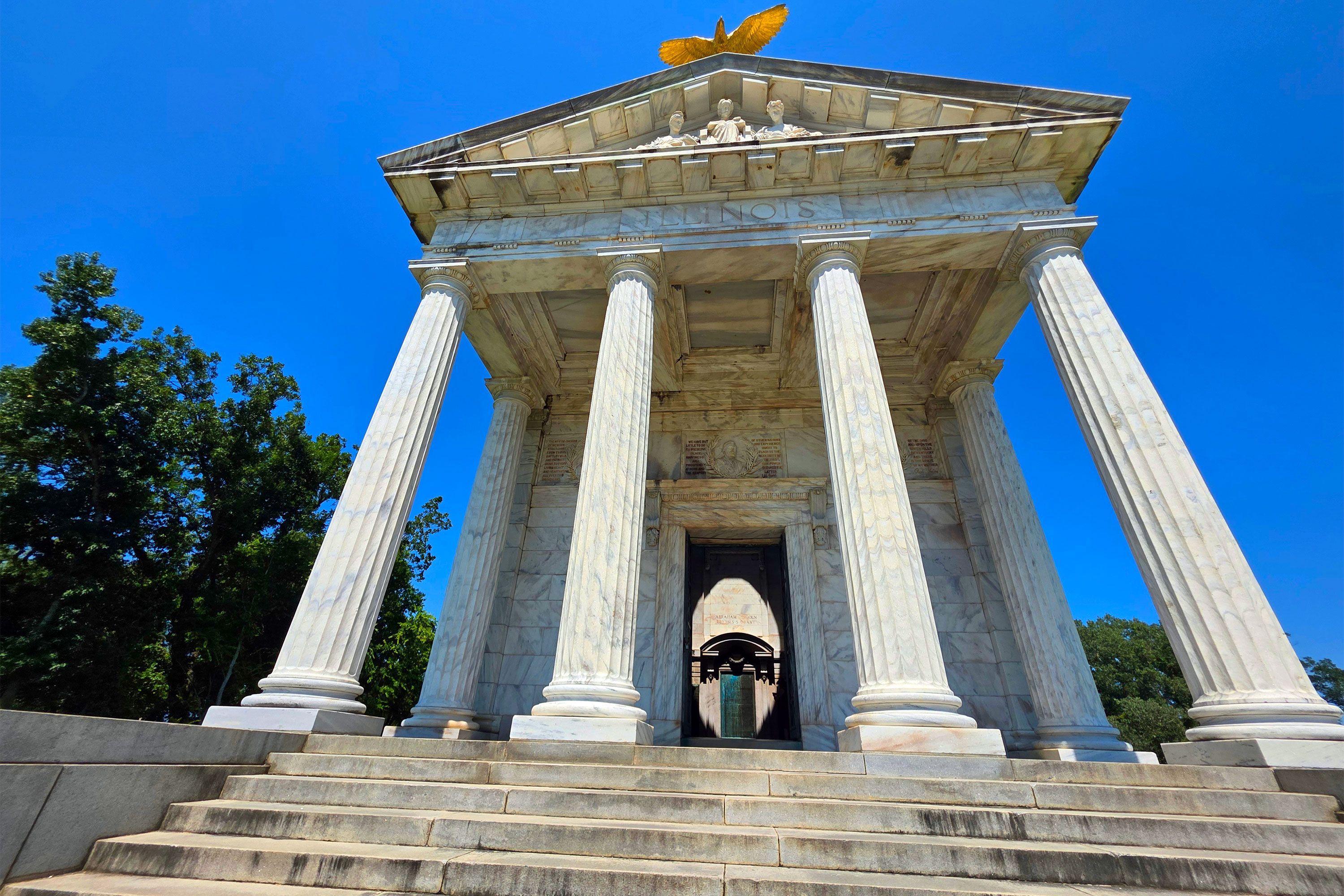 A grand stone memorial resembling a Roman pantheon, with a tall dome and columns, under a partly cloudy sky.
