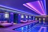 Neon lights illuminate an indoor pool.