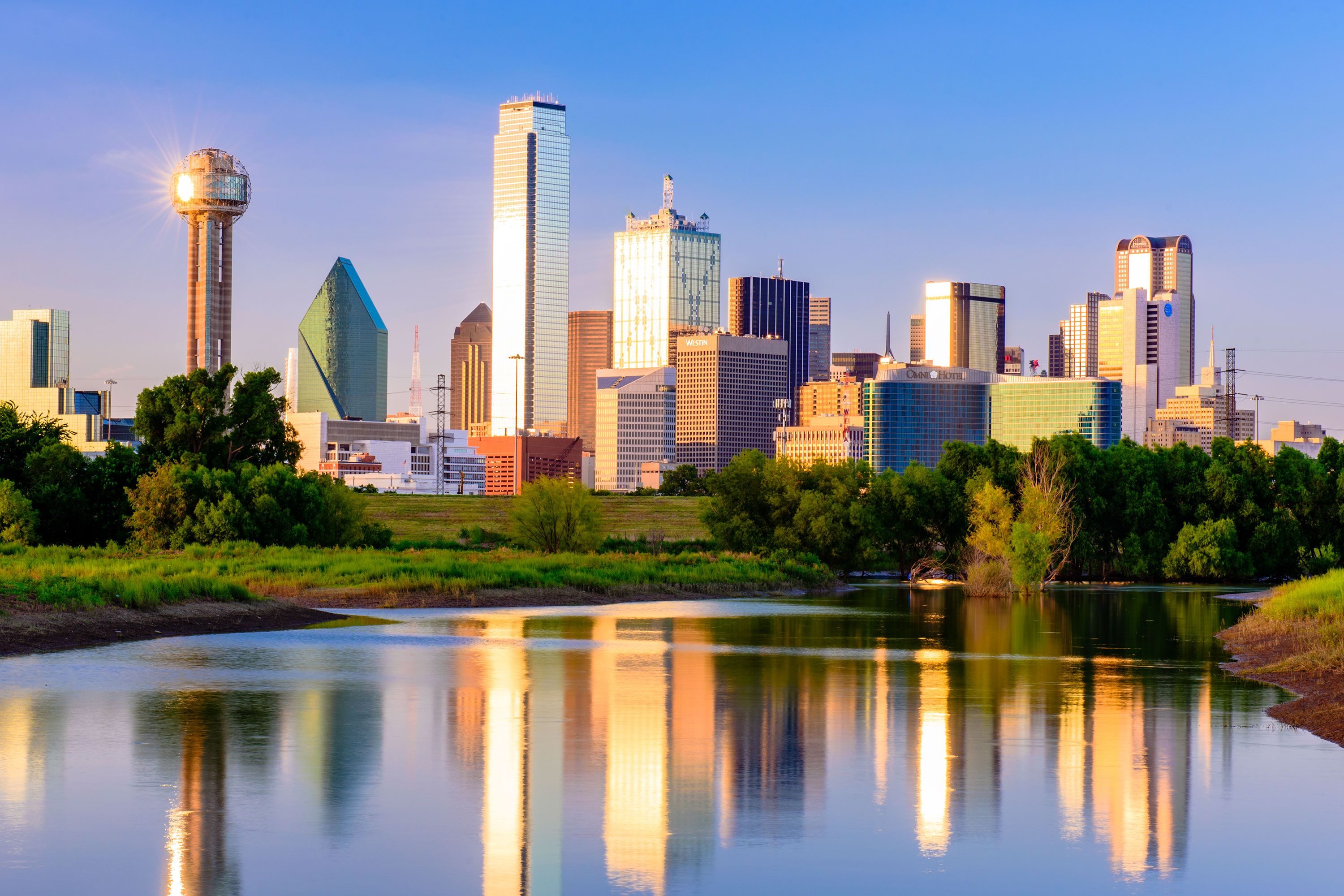 A city skyline reflected in a lake.