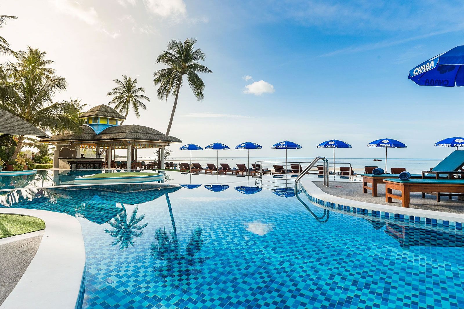 A pool and cabanas at a beach club.