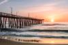 Sunrise viewed from the beach with a wooden pier at Virginia Beach.
