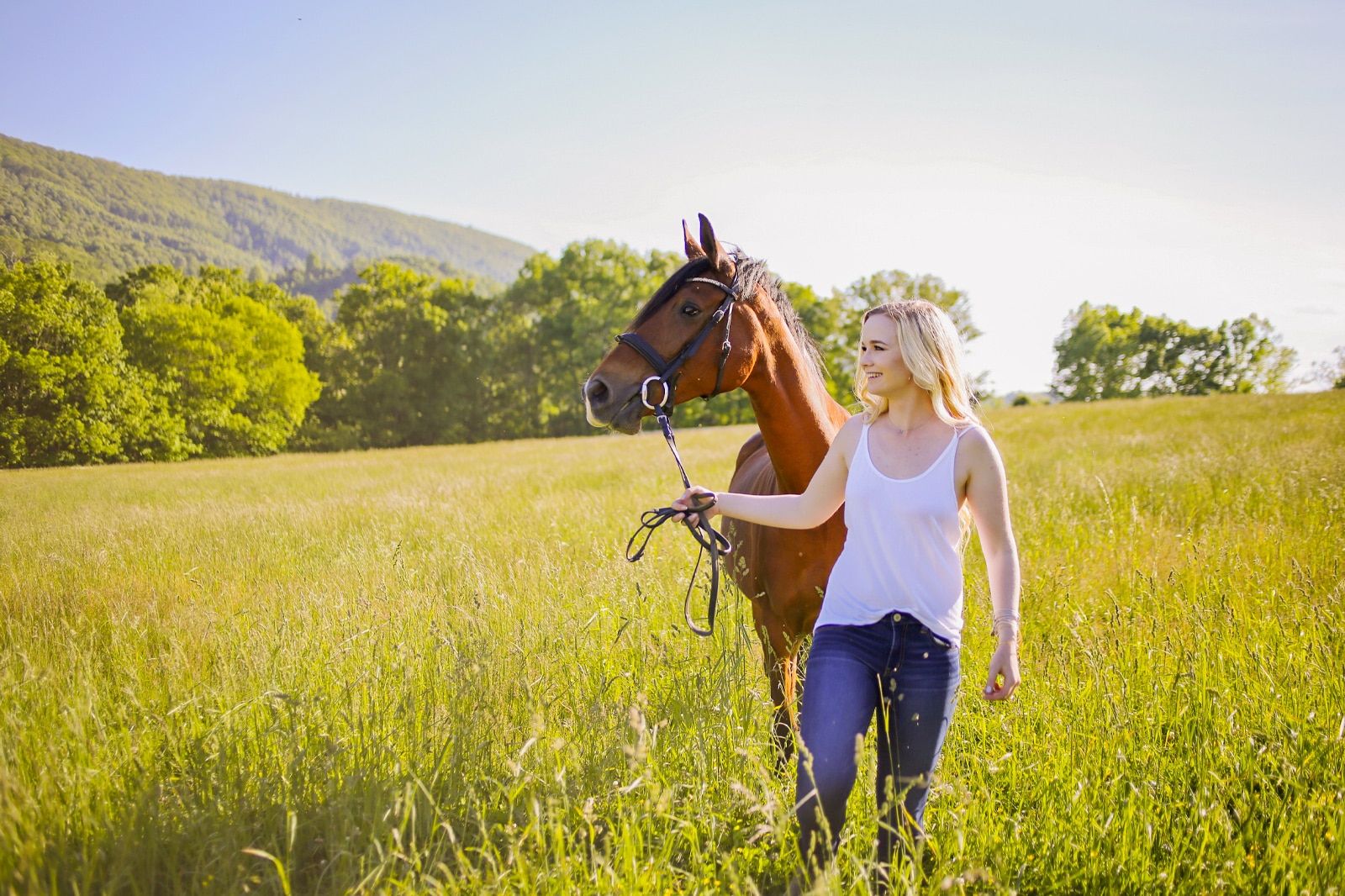 A woman and a horse on a field.