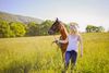 A woman and a horse on a field.
