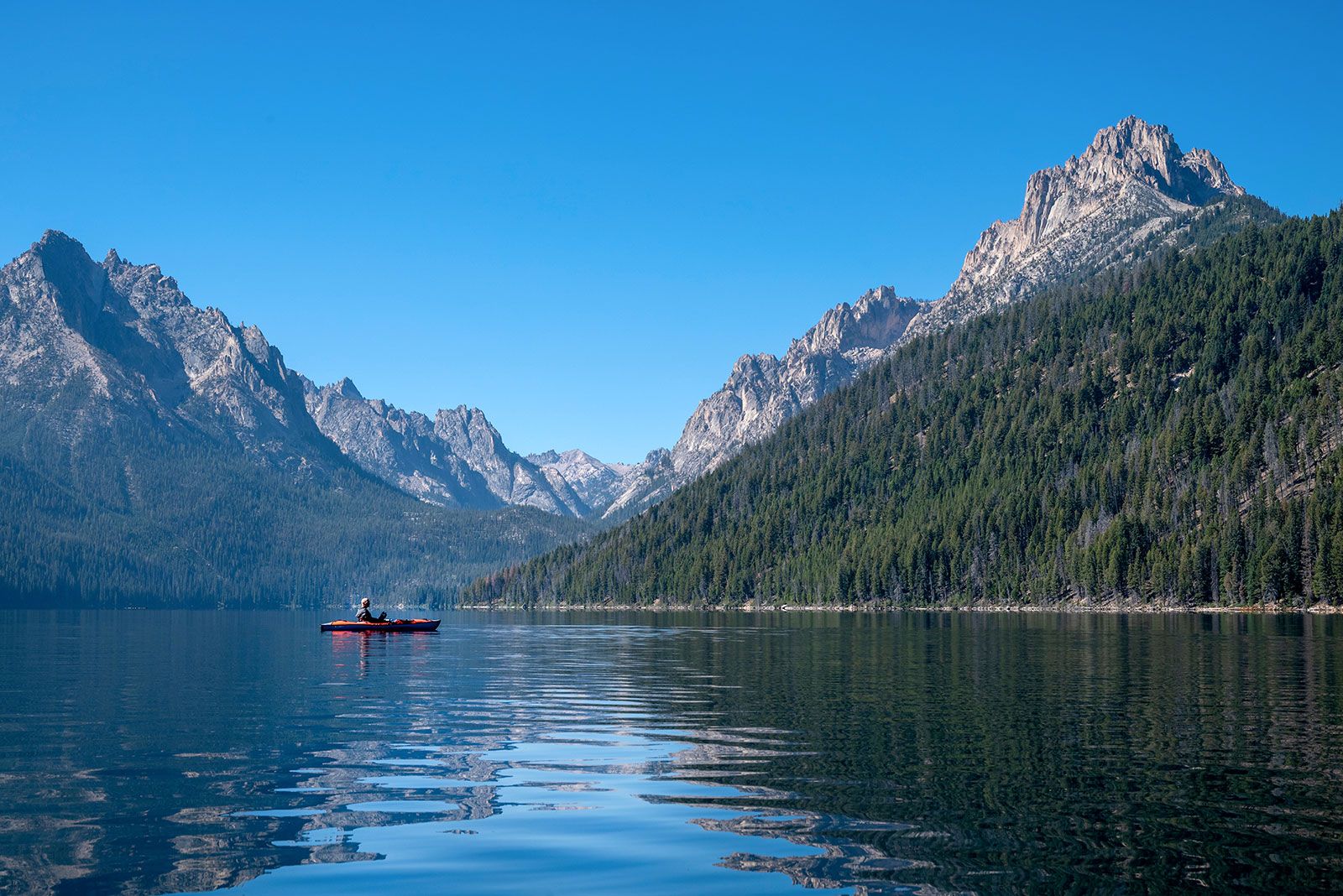 A landscape view of lake and mountains against blue sky.