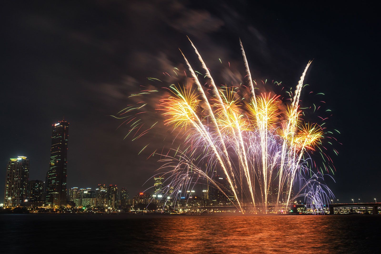 A firework display over the city in the night.