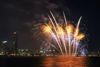 A firework display over the city in the night.