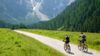 A couple cycling in mountainous surroundings.