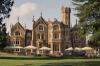 Exterior of Oakley Court in the UK with grand Gothic-style architecture and riverside garden setting.