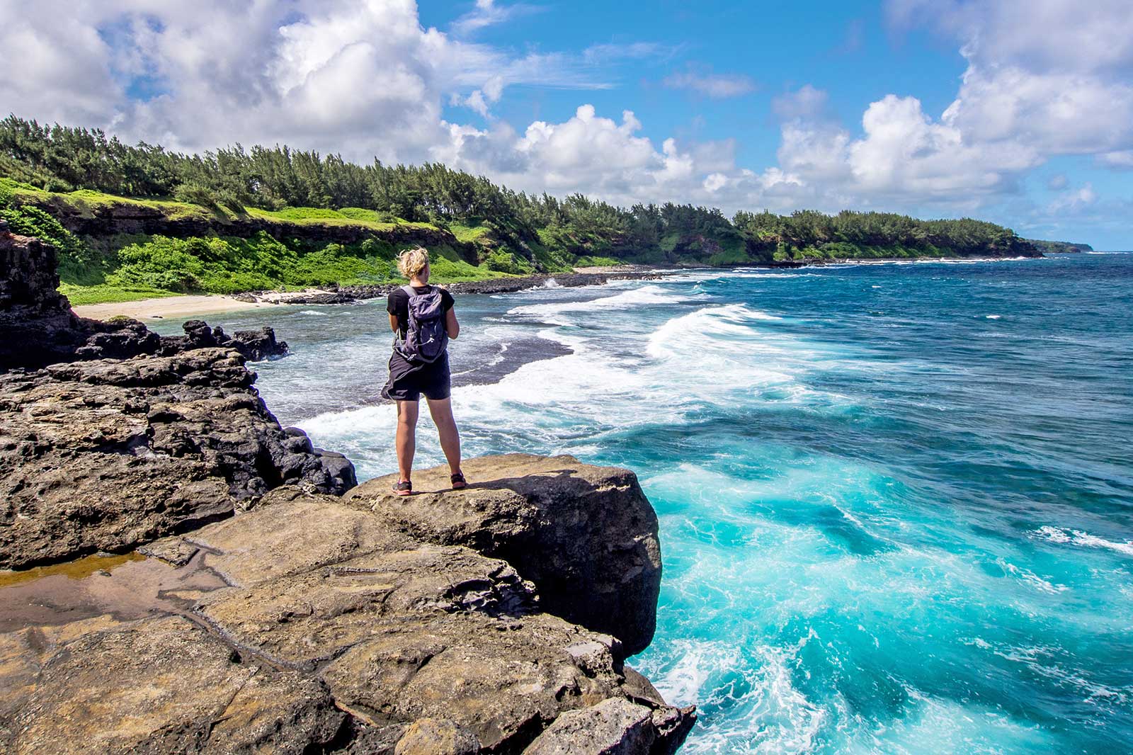 Person watching the waves from a cliff.