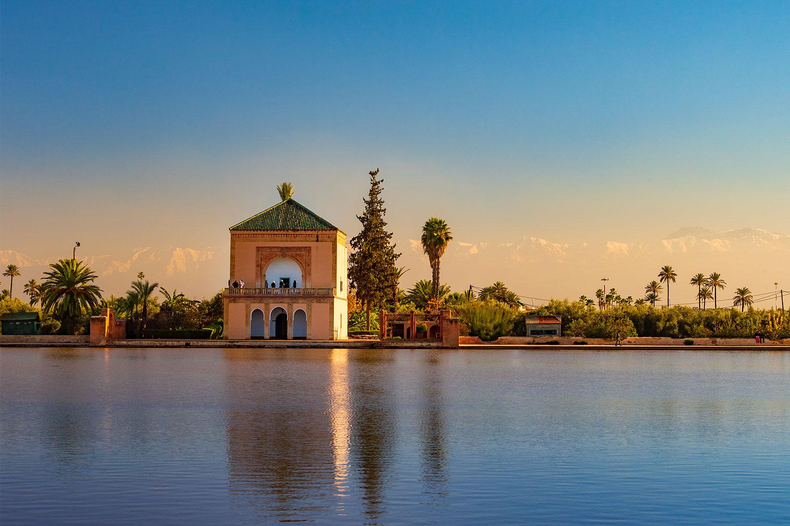 A pavilion reflected on pool in late afternoon light.
