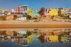 A beach surrounded by colourful houses.