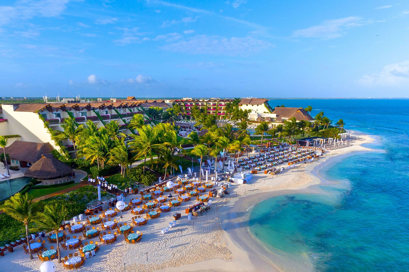 An overhead view of a beach resort with dining on the beach.