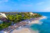 An overhead view of a beach resort with dining on the beach.