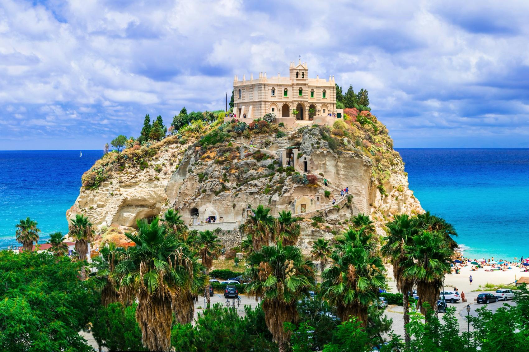 The Santa Maria dell'Isola sits on top of a rock surrounded by the sea in Tropea, Italy.