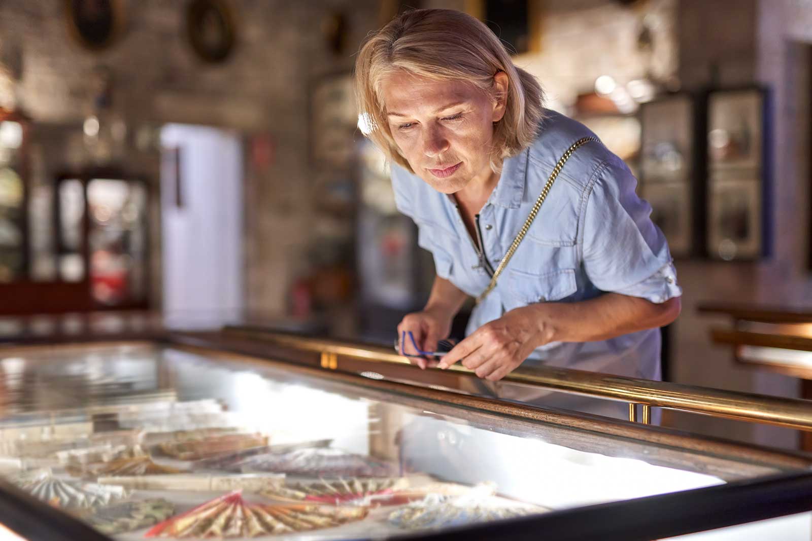 Woman leans over a museum display.