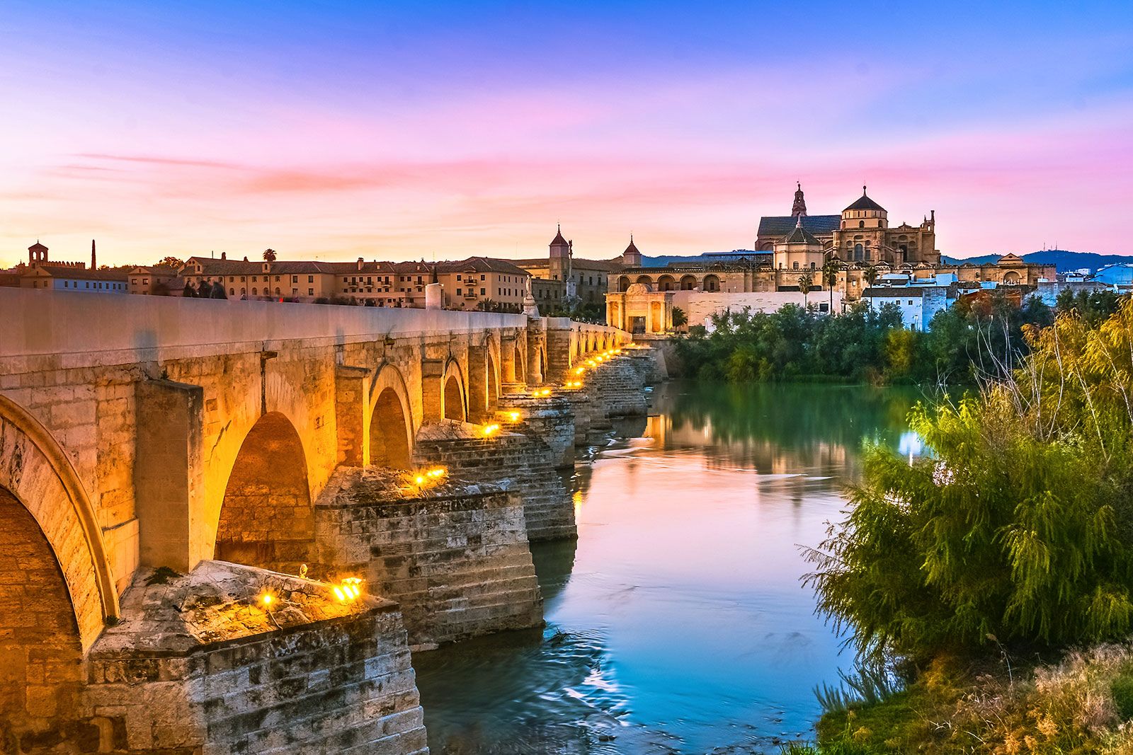 An illuminated Roman bridge of Cordoba in the evening.