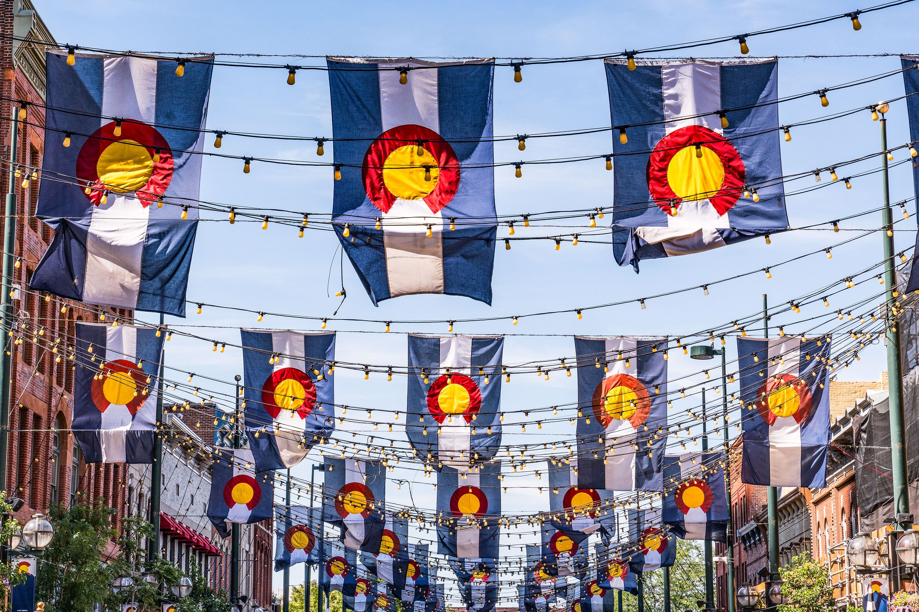 Many rows of flags are strung across a street in downtown Denver. 