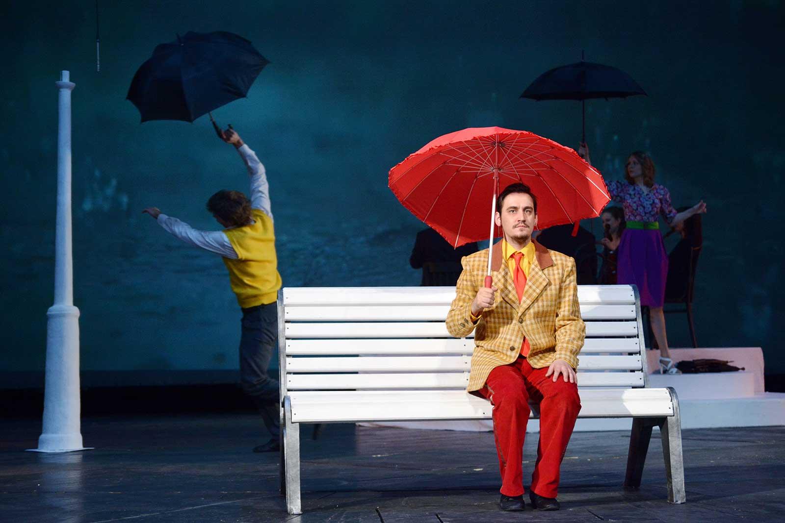 Actors perform on stage.