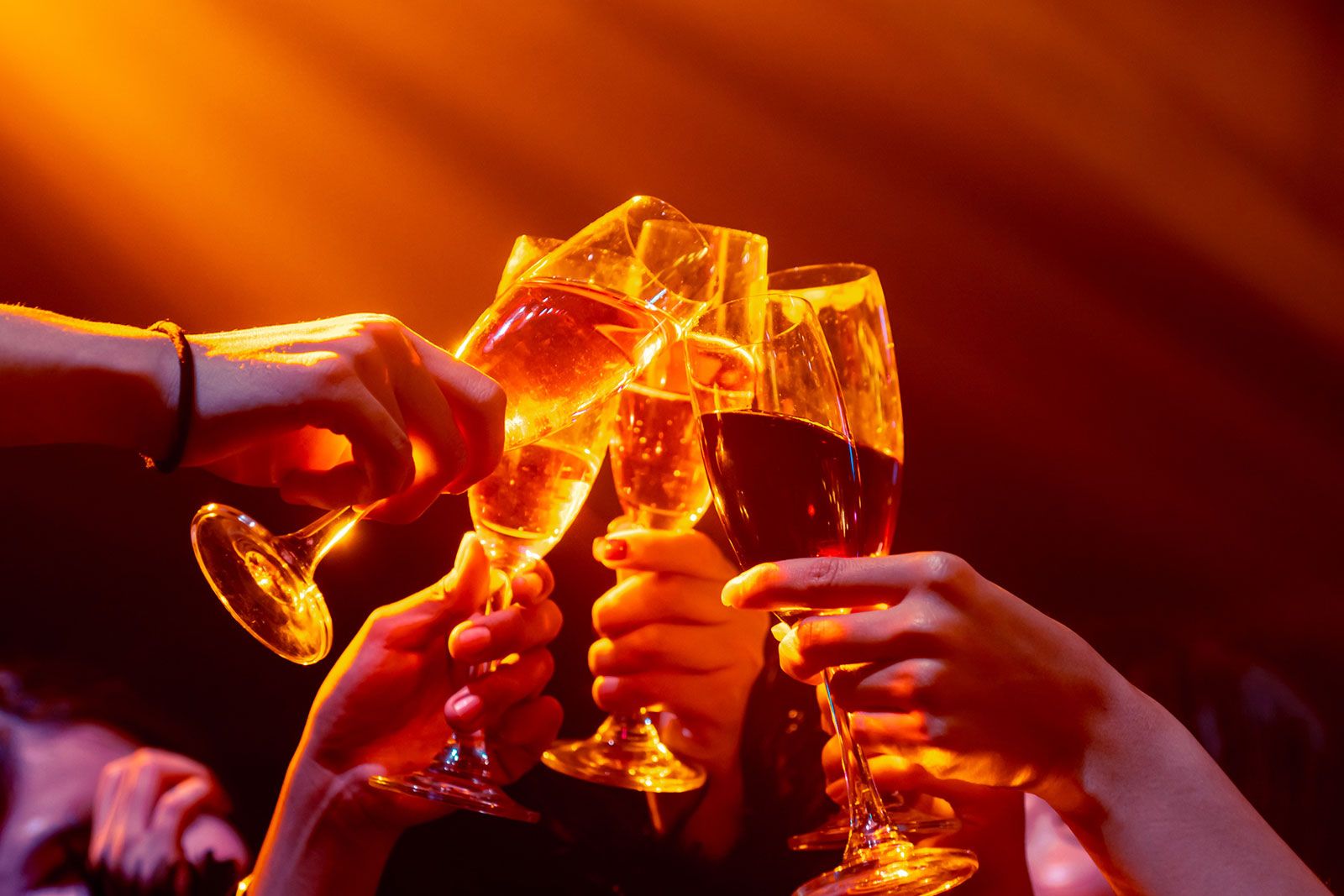 People toasting under nightclub lights.