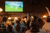 People watching a football match in a bar.