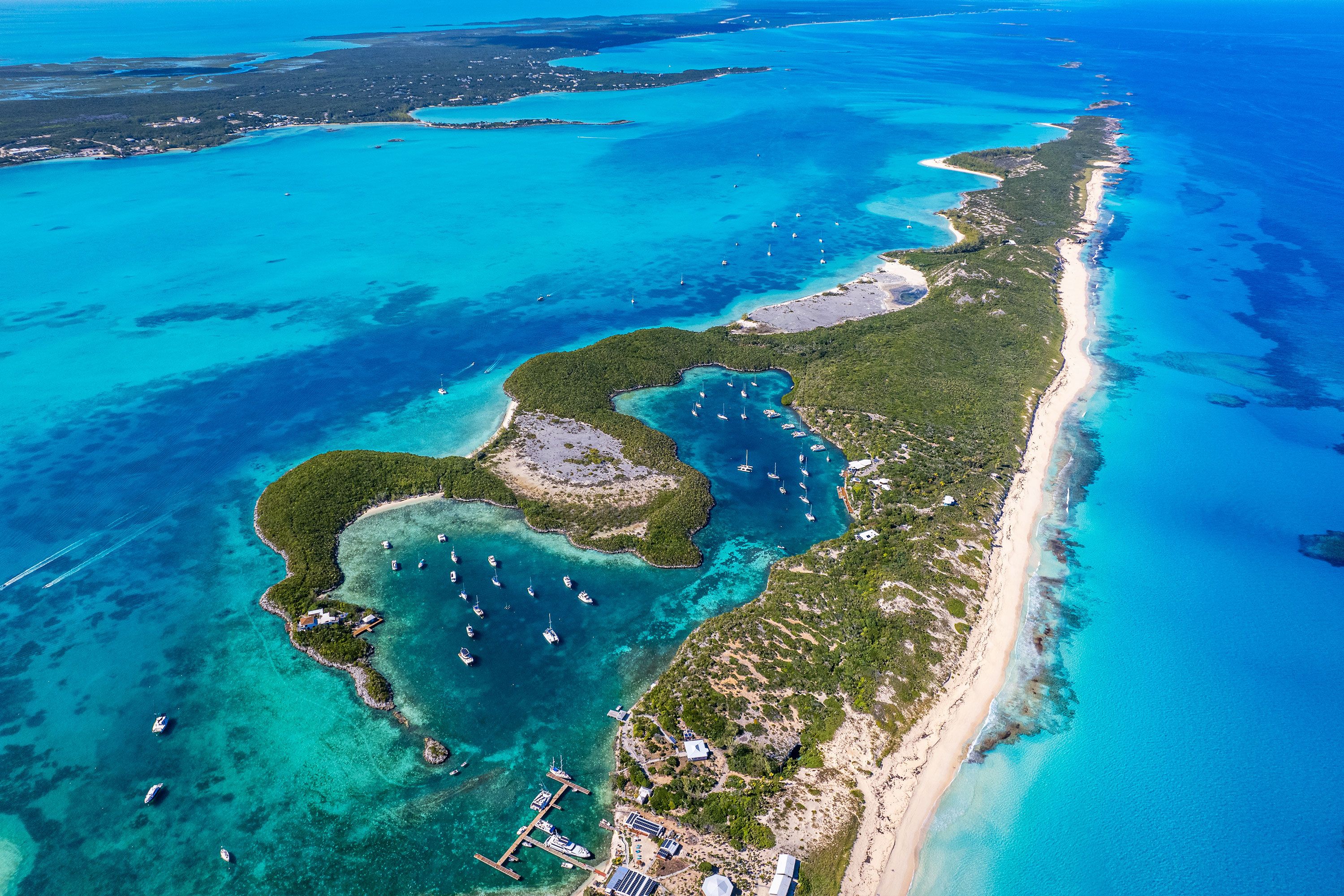An aerial view of an island spanning out in the turquoise waters of the Bahamas.