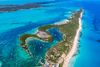 An aerial view of an island spanning out in the turquoise waters of the Bahamas.