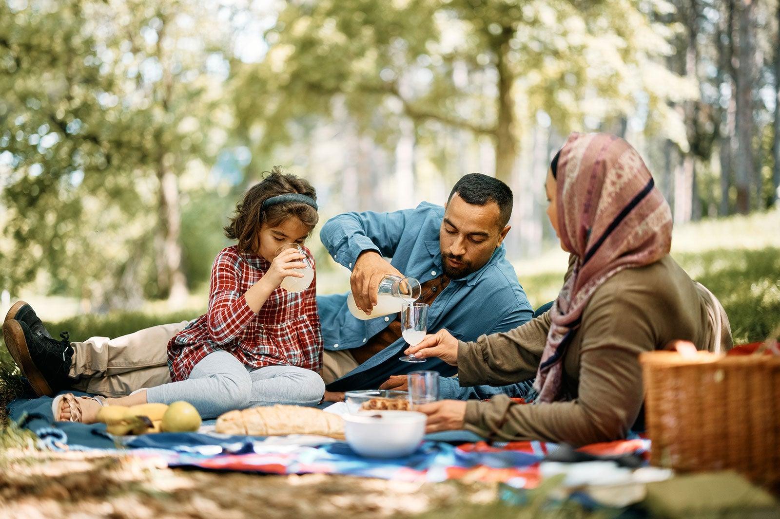 Muslim family having a picnic outside.