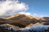 A lake with a mountain range in the background.