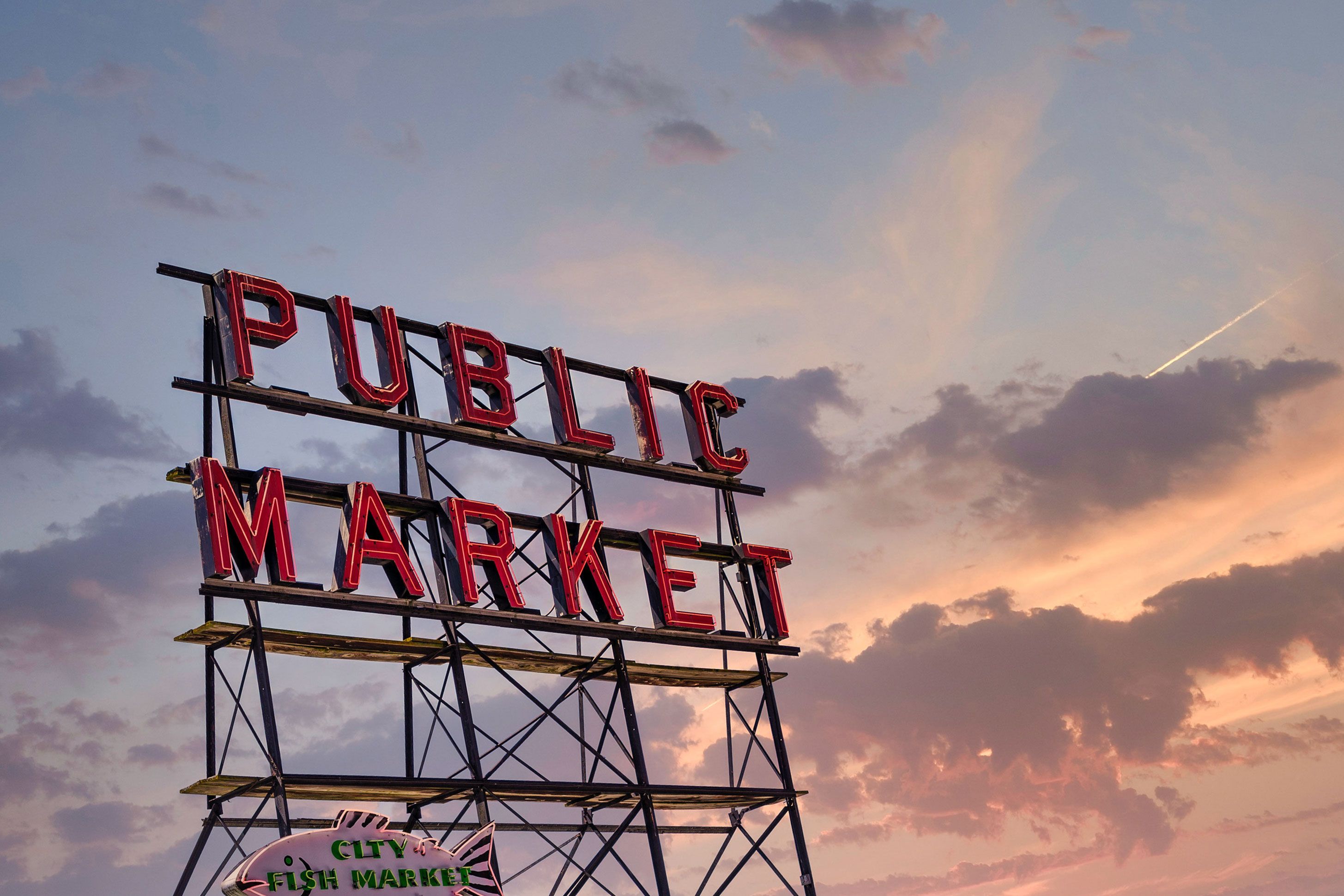 A neon sign for the Pike Place Public Market in Seattle at sunset..
