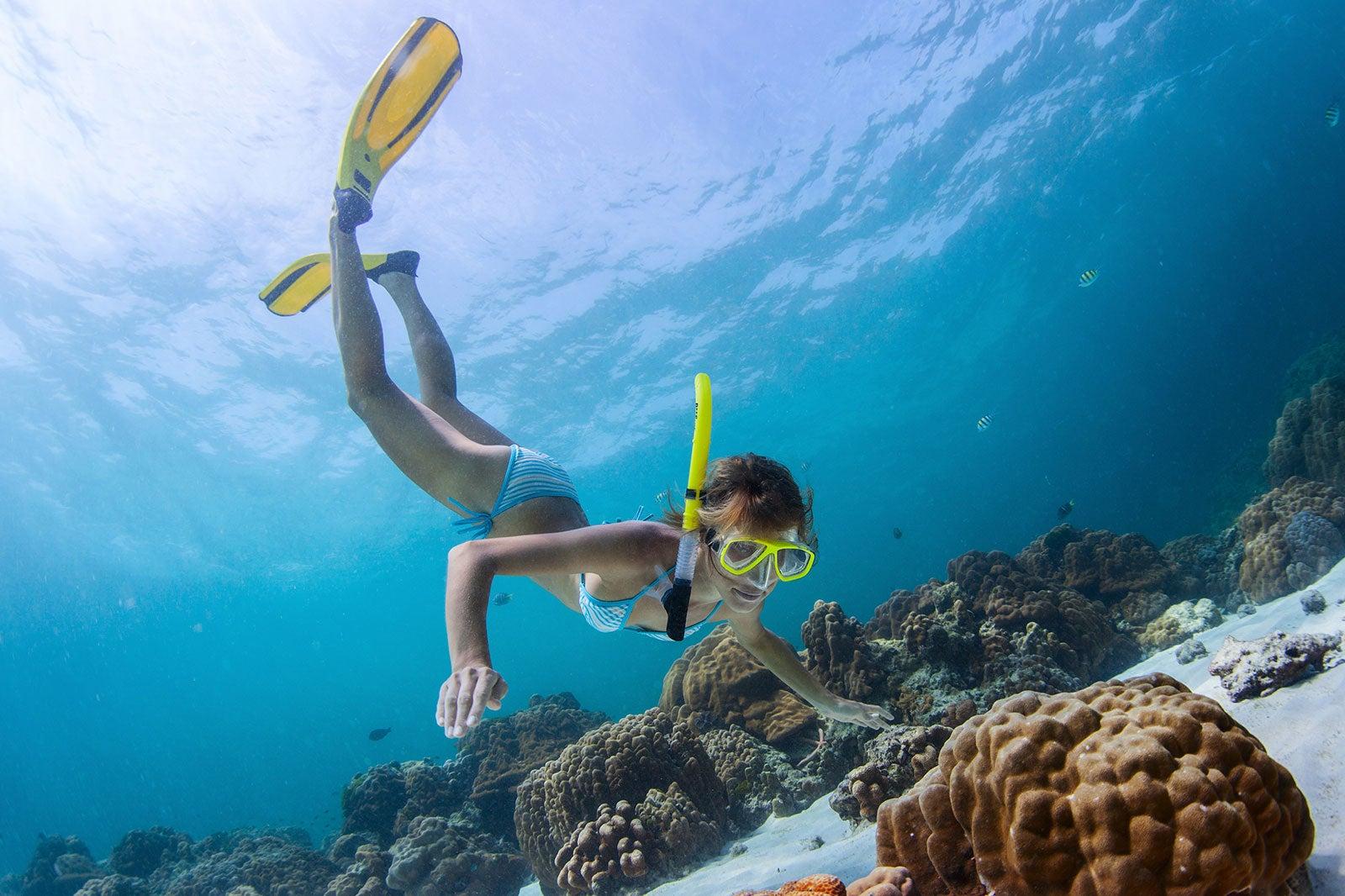 A women with snorkel and fins underwater.