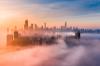 Skyline of Chicago with fog surrounding buildings during a sunset.