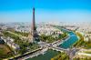 Aerial view of the Eiffel Tower and the river cutting through the city of Paris.