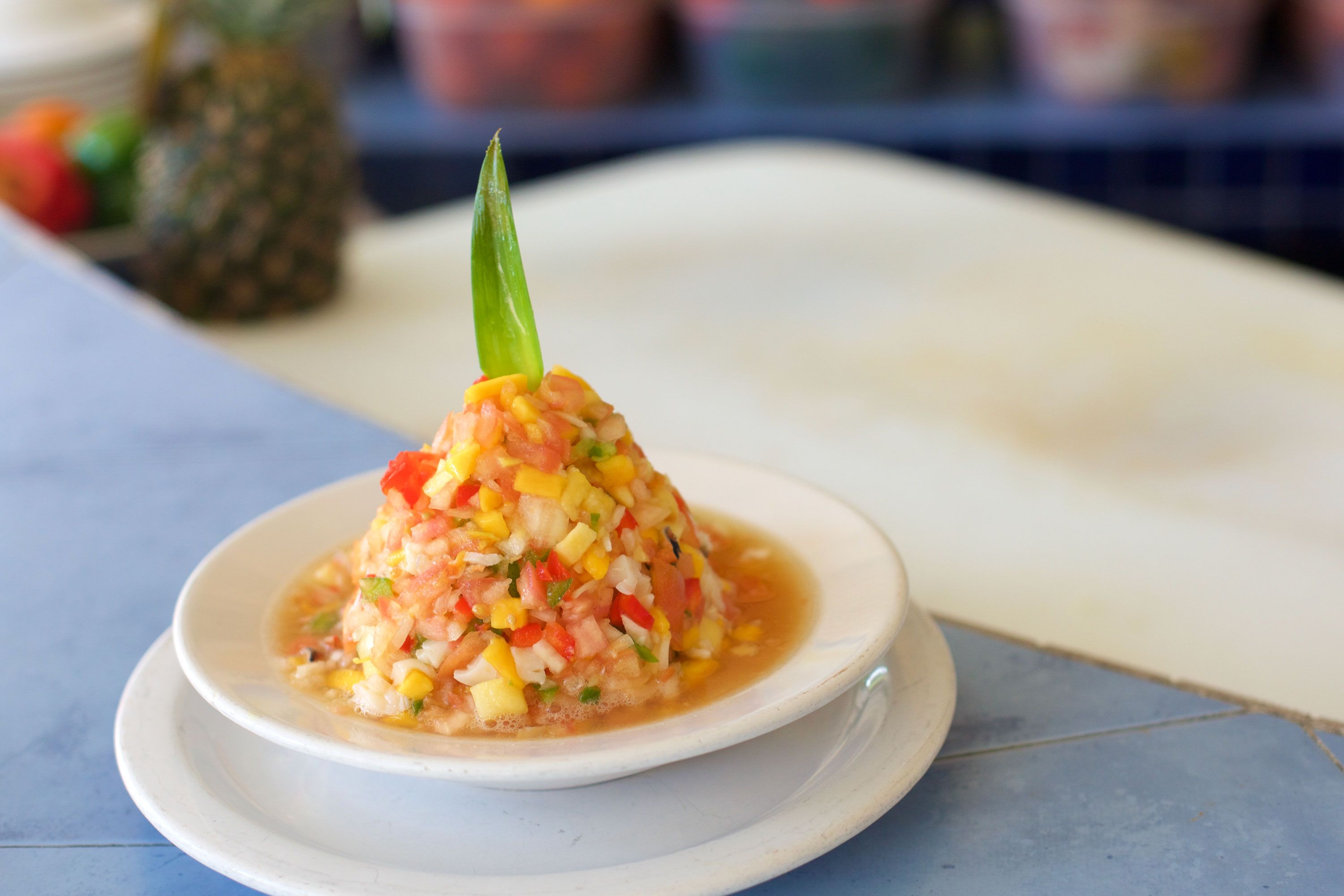 Colorful diced seafood and vegetables stacked neatly on a plate, topped with a green garnish.