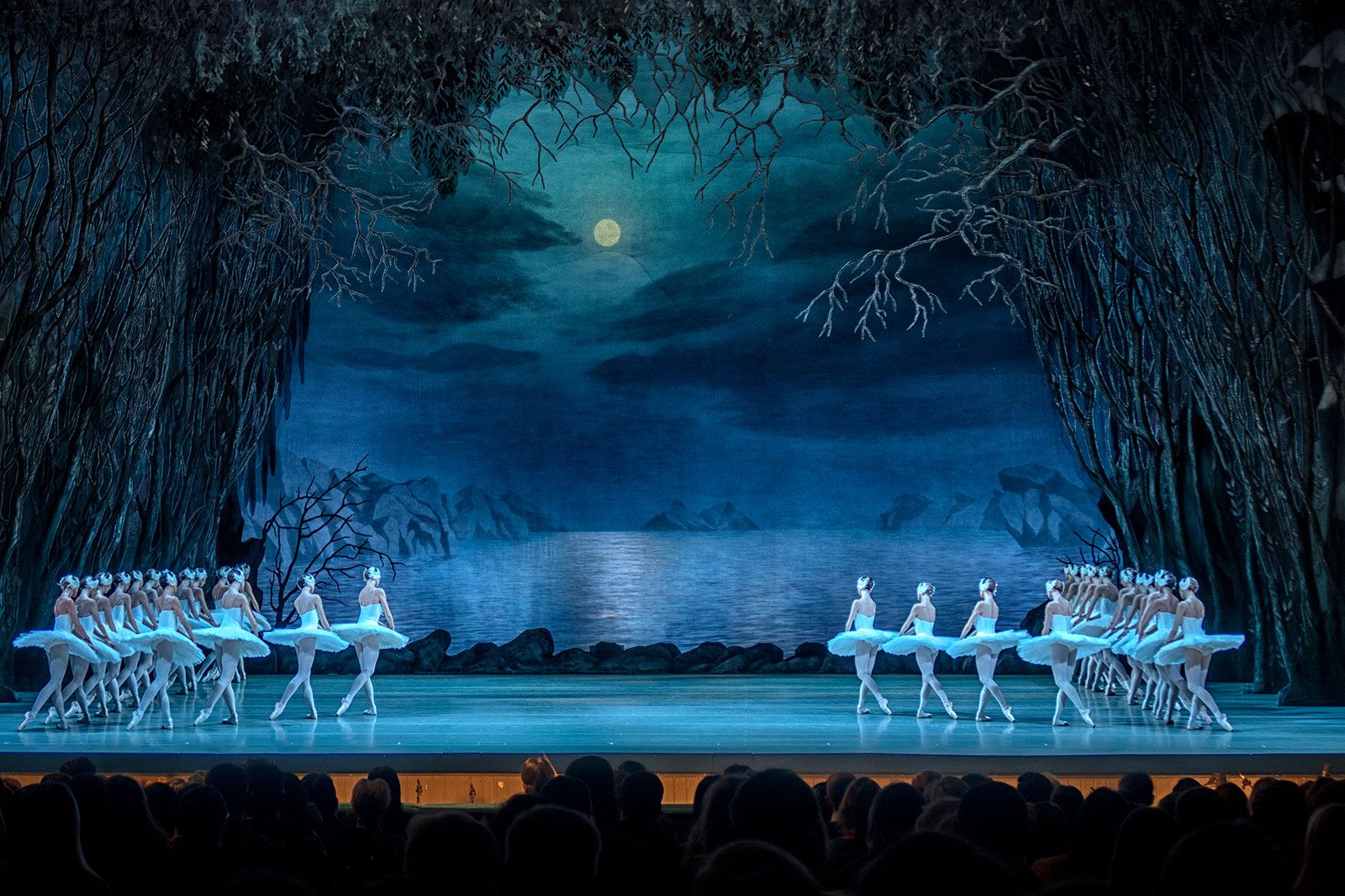 A group of Ballet dancers performing on stage in a theater.