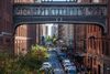 Street lined with red brick buildings, a covered bridge over the street.