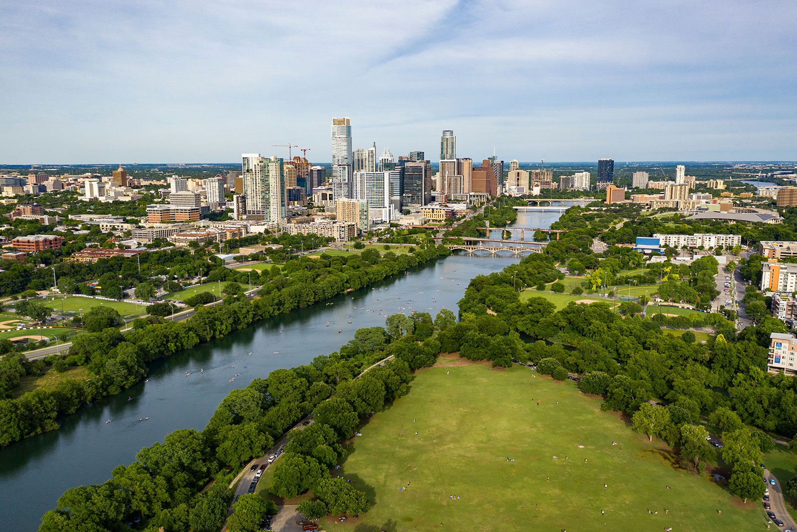 A river flowing between a city surrounded by a park.