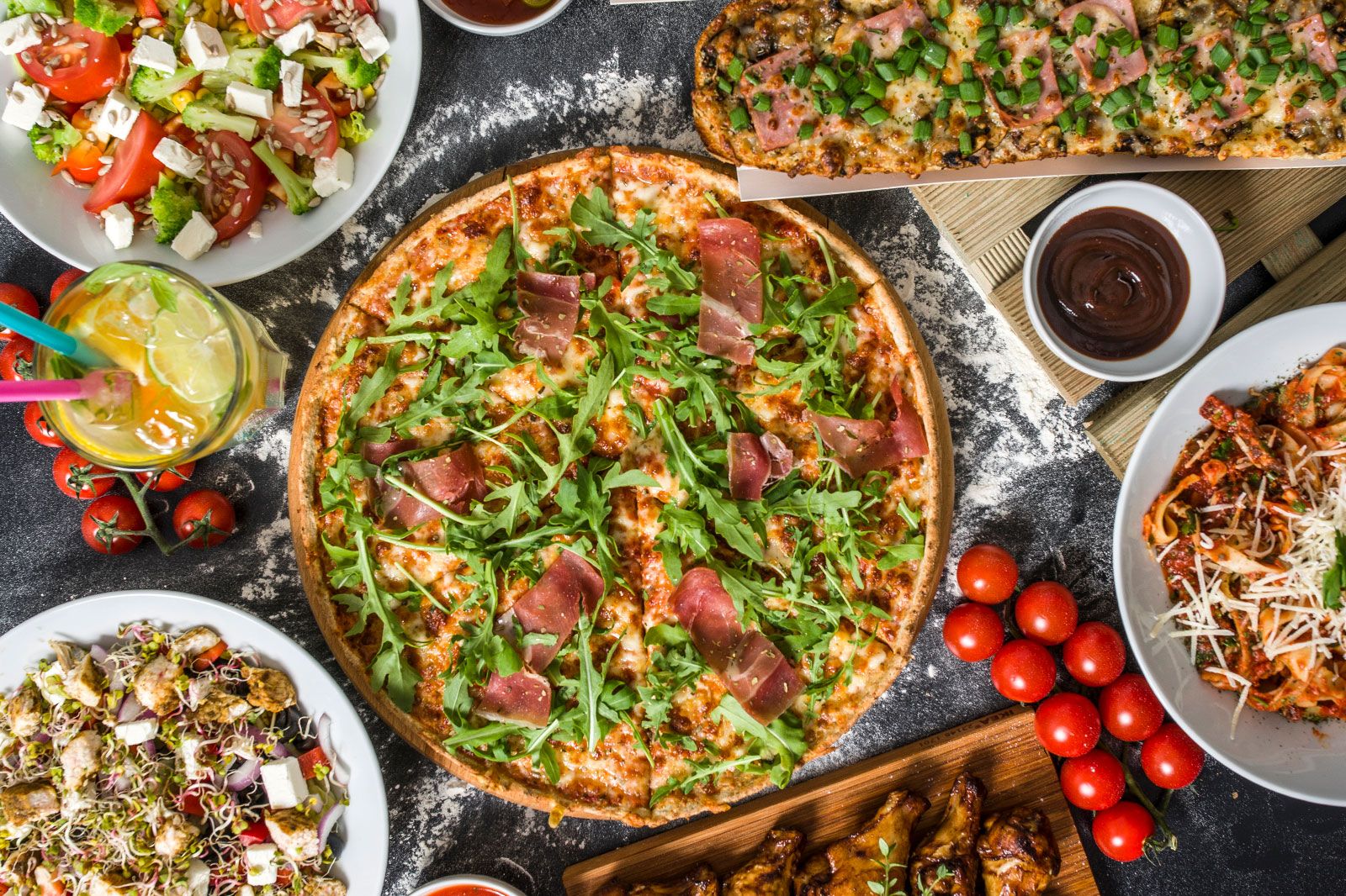 A pizza and appetizers with kept on a table.