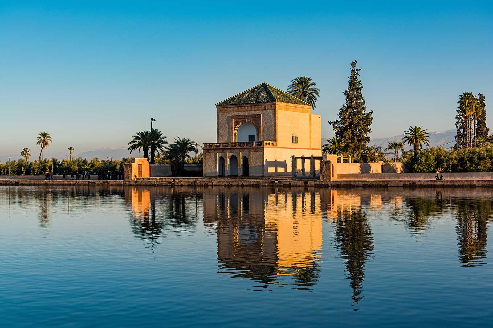 Soft light on a traditional Moroccan building over a pool.