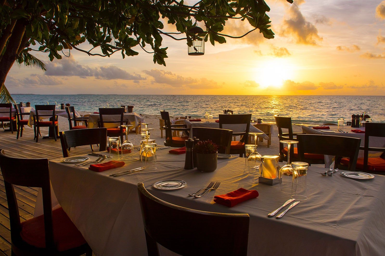 Tables set for dinner in front of the ocean. 