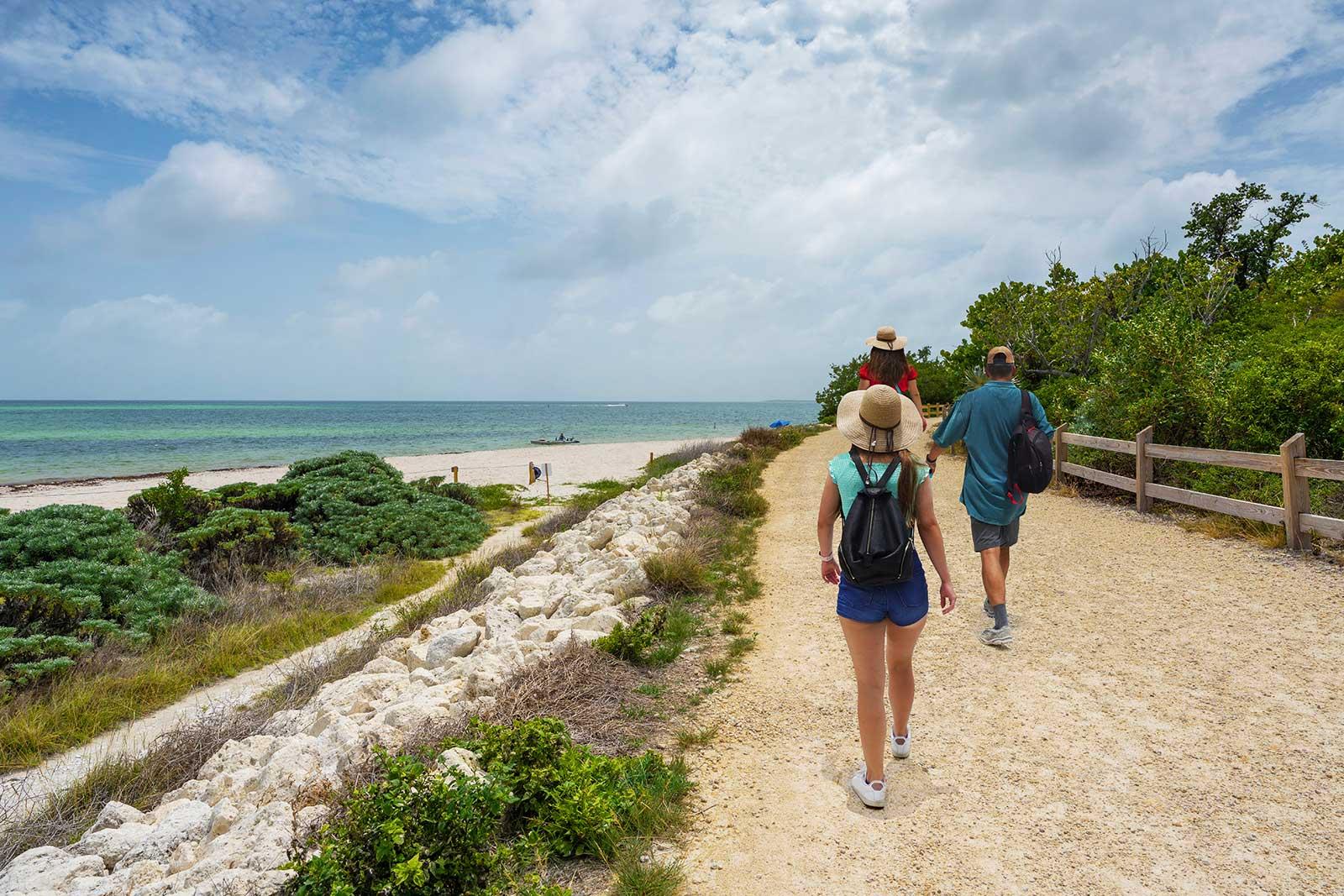A family hiking on a path along the beach.