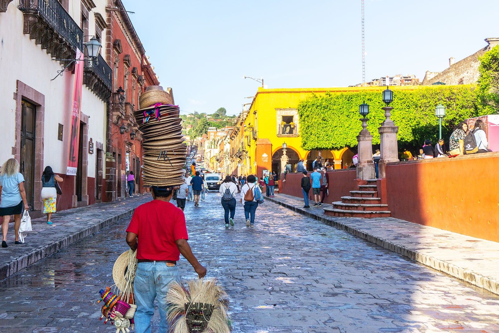 People walking on a gobbled street with colorful houses. 