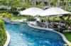 Swim-up canopied bar with lazy river set in a tropical garden.