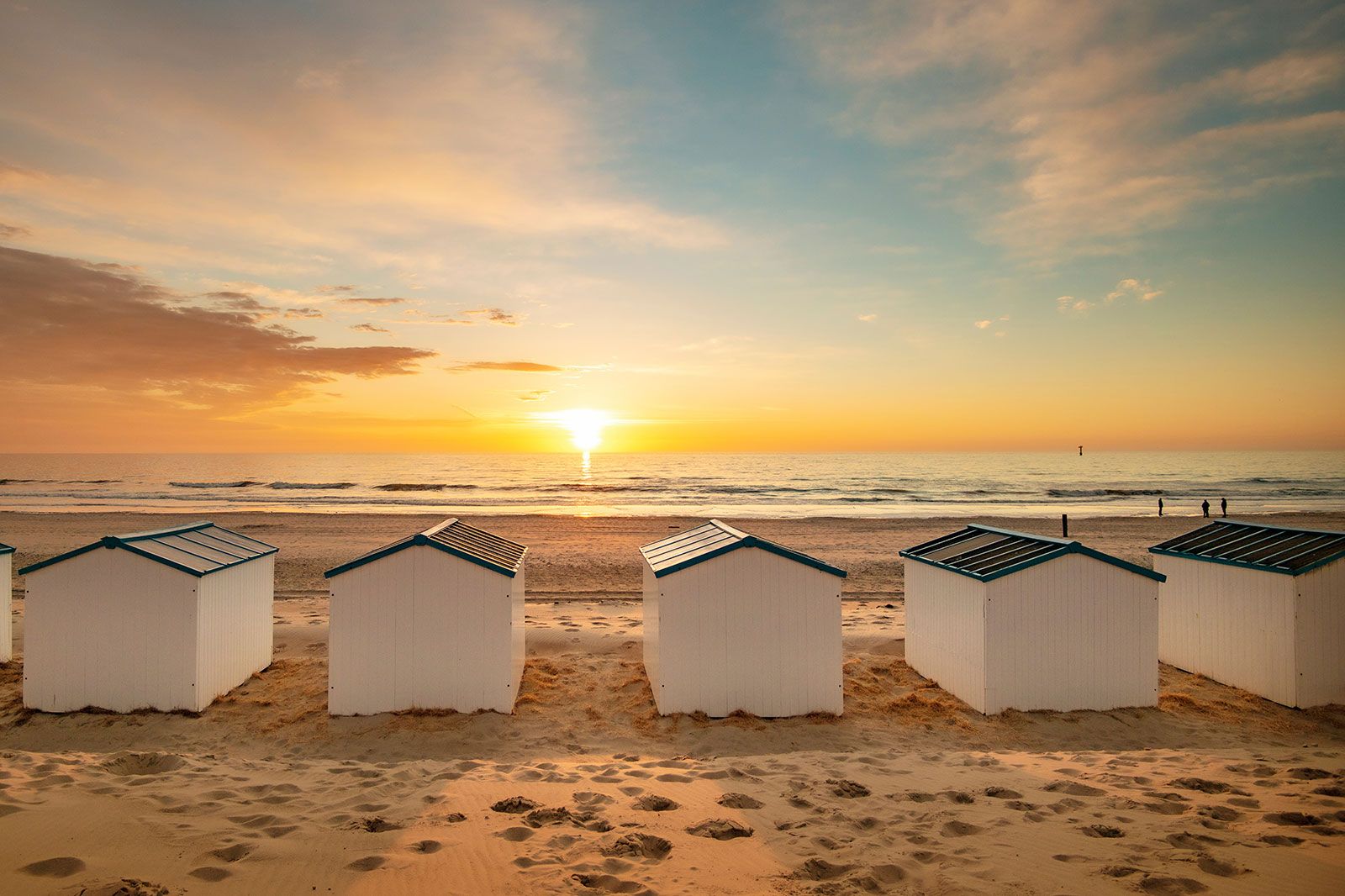 Beachhouses on the beach at sunset.