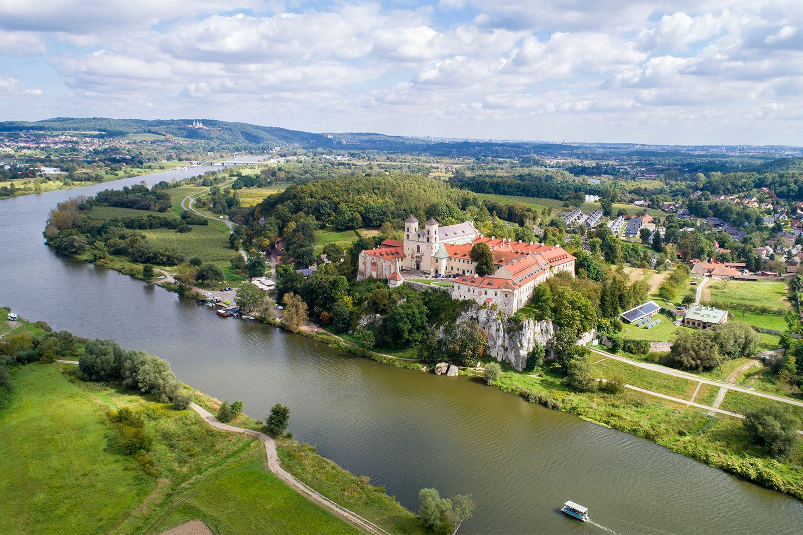 A view from a drone of the a large castle along a river.